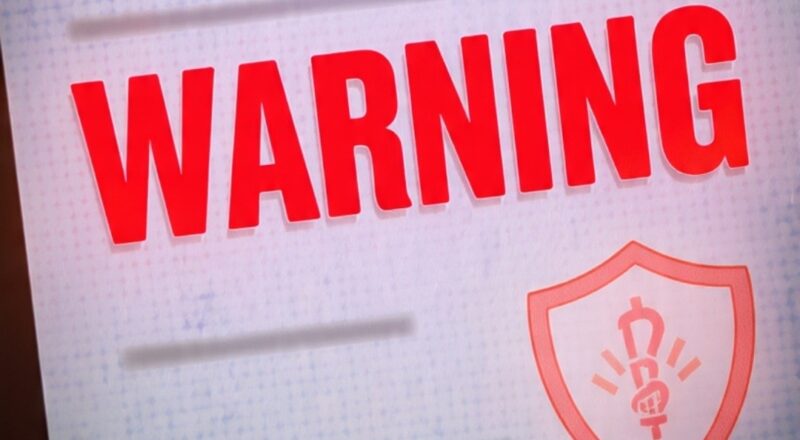 medicare card with red warning sign fraud scam alert for seniors 2026